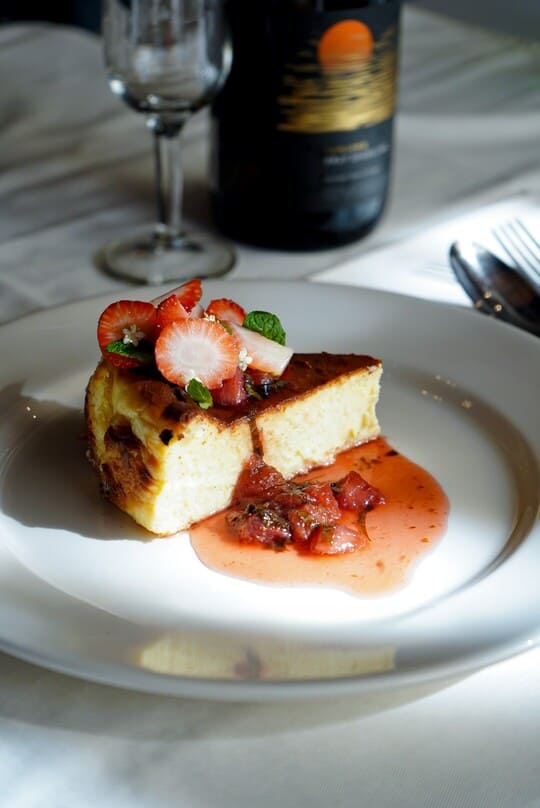 Homemade Burnt Basque Cheesecake pastry topped with fresh strawberries, a signature cake for dessert at Rah Nah Restaurant Lovina.