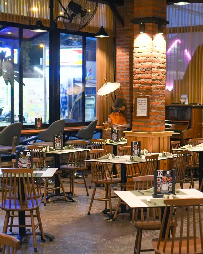 Warmly lit dining space with views of the street, perfect for a relaxed dinner at this popular Lovina bar and restaurant.